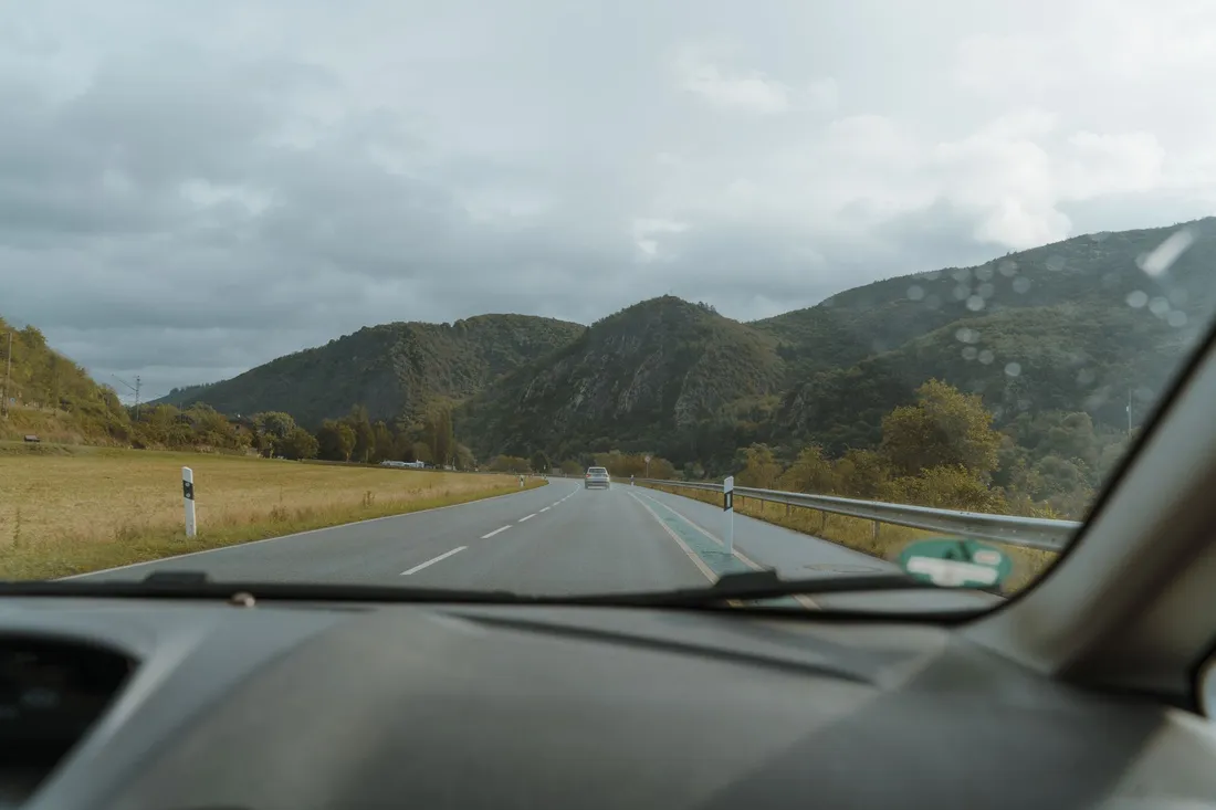 Blick durch die Windschutzscheibe auf die freie Straße, vor der langen Fahrt